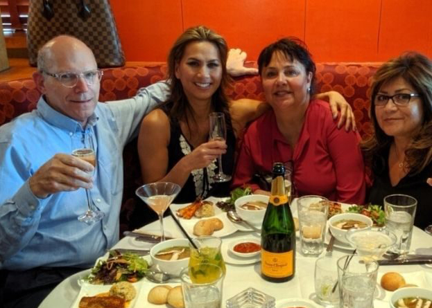 Four people enjoying a meal at a restaurant.