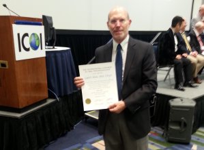 Man holding award at ICOOL conference.