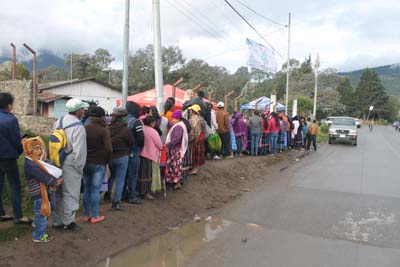 People waiting in line along rural road